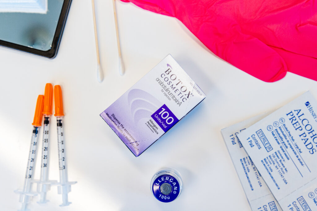 Supplies prepared for a Botox treatment in Plano. There is a box, a bottle, and a syringe neatly placed on a counter.